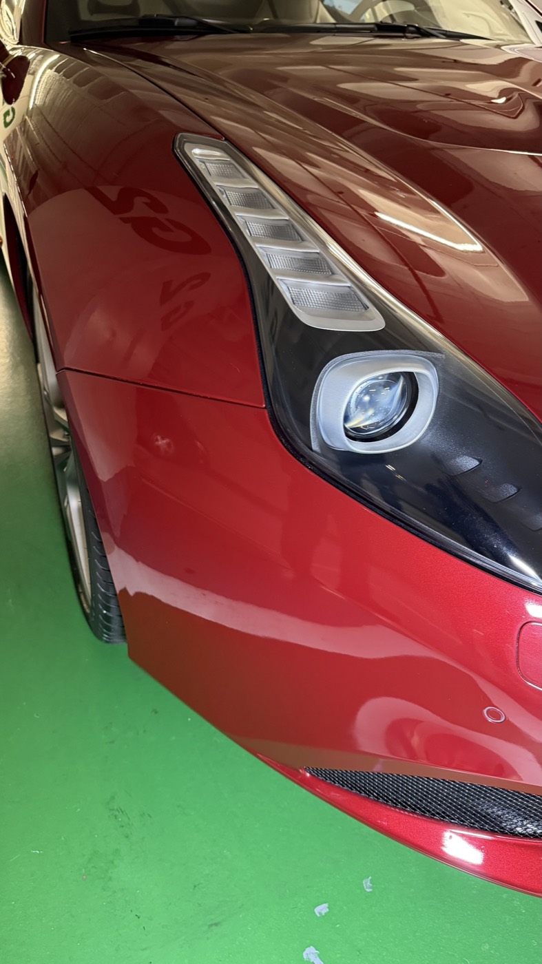 Detalhe de farol e pintura numa viatura premium vermelha