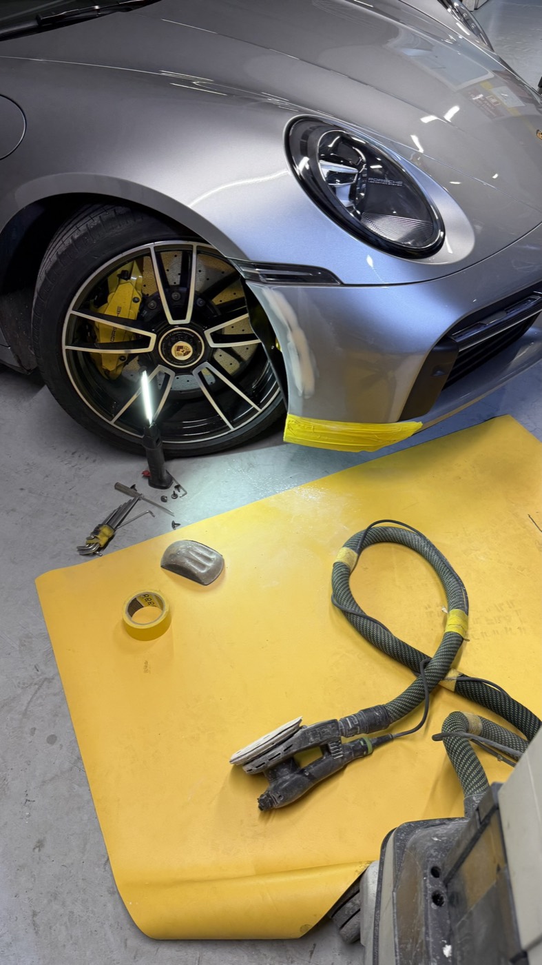 Detalhe de roda e para-lama de Porsche na oficina
