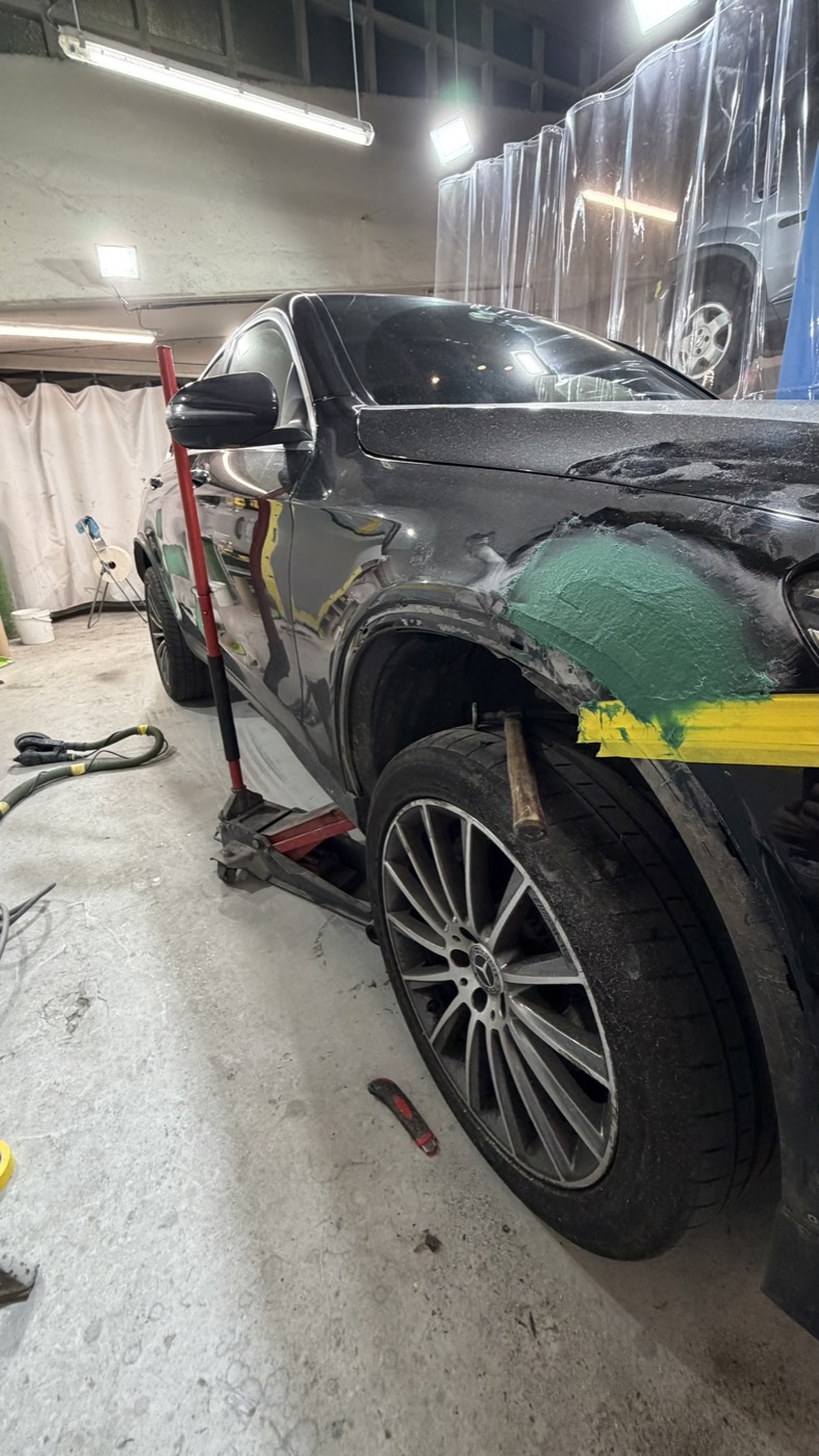 SUV em reparação de bate-chapa, massa aplicada no guarda-lamas